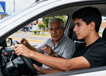 Estudiante aprendiendo a manejar con instructor en escuela de conducción en Cali durante curso para obtener licencia de conducción.